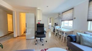 a kitchen and living room with a chair and a table at Gjestehus i Tveit in Kristiansand