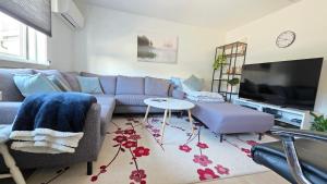 a living room with a couch and a tv at Gjestehus i Tveit in Kristiansand