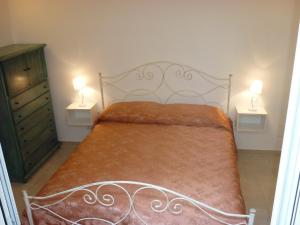 サンニコーラにあるDimora Montesantoのベッドルーム1室(ベッド1台、ランプ2つ、テーブル2台付)