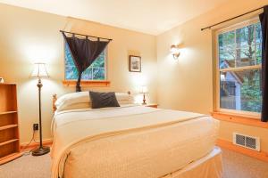a bedroom with a large bed and two windows at Twin Lakes Cabin in Glacier
