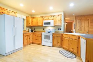 a kitchen with wooden cabinets and a white refrigerator at Twin Lakes Cabin in Glacier