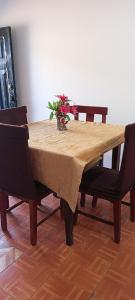 a wooden table with a vase of flowers on it at Alojamientos La Escapadita in Manta