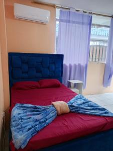 a bed with a blanket on it with a window at Alojamientos La Escapadita in Manta +23 photos