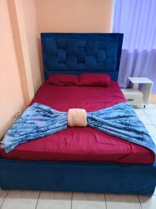 a blue bed with a red blanket on it at Alojamientos La Escapadita in Manta