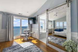 a bedroom with a bed with a view of the ocean at Sunrise Waterfront Retreat in Milford
