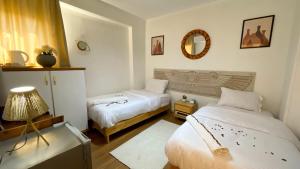 a bedroom with two beds and a lamp and a mirror at RAFiF Pyramids View Hotel in Cairo