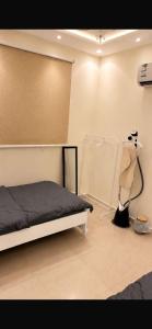 a bedroom with a bed and some clothes and a wall at شقه فندقه in Hail