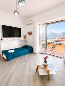 a bedroom with a blue bed and a large window at Sul Mare Apartment - Seafront with Sea View in Salerno