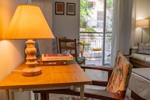 a table with a lamp and a book on it at Studio74 in Patra