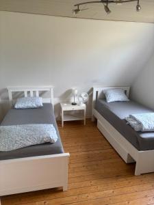 a bedroom with two beds and a night stand at Villa in Kvidinge
