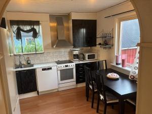 a kitchen with a table and a kitchen with white appliances at Villa in Kvidinge