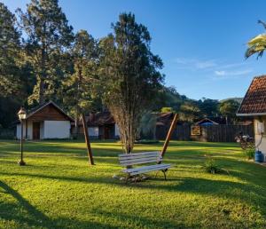 a park bench sitting in the middle of a yard at Palmeira Azul in Visconde De Maua