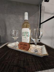 a bottle of wine and two wine glasses on a table at Araxovoli Studios - Aραξοβόλι Lefkada in Tsoukalades +44 photos