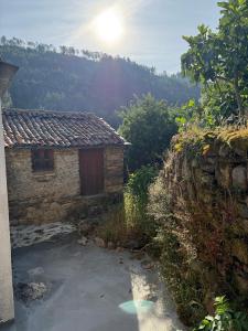 a small stone building with the sun in the background at Casa D Matilde in Góis