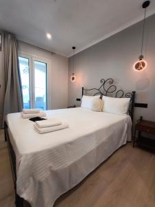 a bedroom with a large white bed with towels on it at Araxovoli Studios - Aραξοβόλι Lefkada in Tsoukalades