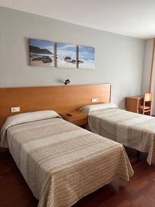 a hotel room with two beds in a room at Hostal El Poligono in Zamora