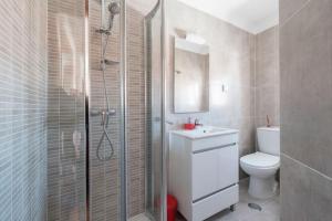 a bathroom with a shower and a toilet and a sink at Ericeira Apartments in Ericeira