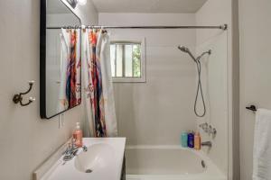 a bathroom with a sink and a tub and a mirror at Walk to Downtown Chico! Tree-Lined Apt w/ Deck in Chico +23 photos