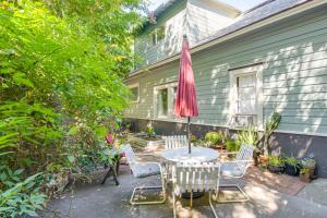 a patio with a table and chairs and an umbrella at Walk to Downtown Chico! Tree-Lined Apt w/ Deck in Chico