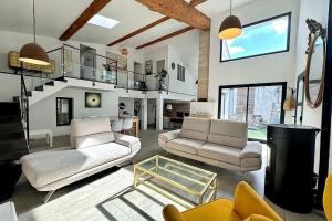 a living room with two couches and a staircase at Maison Loft atypique - Jacuzzi clim et jardin in Saint-Jean-de-Védas