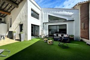 a living room with a green lawn in front of a house at Maison Loft atypique - Jacuzzi clim et jardin in Saint-Jean-de-Védas