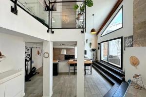 an open kitchen and dining room with a staircase in a house at Maison Loft atypique - Jacuzzi clim et jardin in Saint-Jean-de-Védas +12 photos
