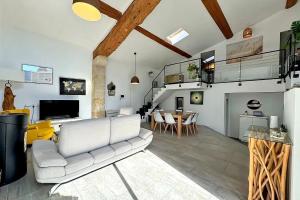 a living room with a white couch and a table at Maison Loft atypique - Jacuzzi clim et jardin in Saint-Jean-de-Védas