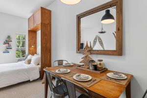 a dining room with a table and a mirror at Trailside Escape a Ski-In Ski-Out Studio in SilverStar in Vernon