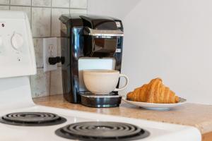 a coffee maker and a cup of coffee and a plate of bread at Trailside Escape a Ski-In Ski-Out Studio in SilverStar in Vernon +40 photos