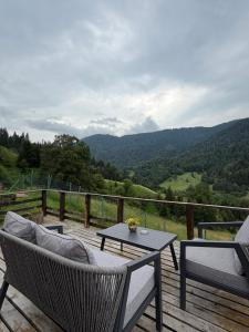 a patio with a table and chairs on a wooden deck at Mitarbi Silence - cozy holiday cottages in mountains 