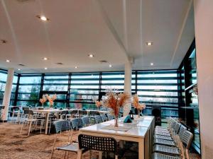 a large room with tables and chairs and windows at Sea Power Studio Loft in Jastrzębia Góra