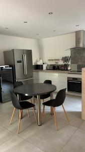 a kitchen with a black table and chairs in it at maisonnette in Menglon