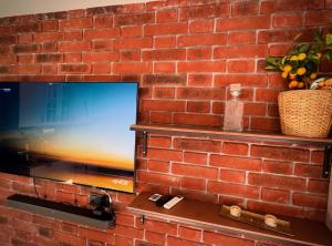 a brick wall with a flat screen tv on it at Sea Power Studio Loft in Jastrzębia Góra