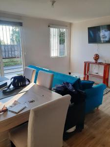 a living room with a blue couch and a table at Depto Condominio Buena Vista in Coronel