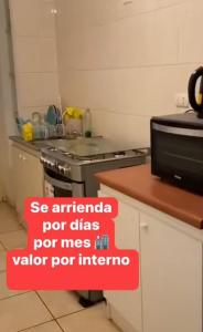 a sign in a kitchen with a stove and a counter at Depto Condominio Buena Vista in Coronel