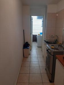a kitchen with a tile floor and a hallway at Depto Condominio Buena Vista in Coronel