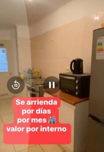 a kitchen with a counter with a sign on it at Depto Condominio Buena Vista in Coronel