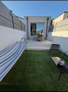 a backyard with a hammock on the side of a house at Entre Terre et Mer, logement cosy in Poussan