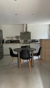 a kitchen with a table and chairs in a room at maisonnette in Menglon