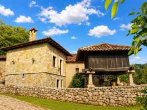 an old stone house with a stone wall at La Casina de Celorio in Celorio