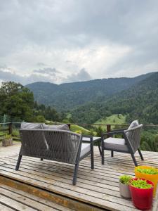 two chairs on a deck with a view of a mountain at Mitarbi Silence - cozy holiday cottages in mountains 