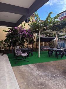 a patio with tables and chairs on a green rug at Vila Vienna in Donji Štoj
