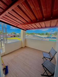 a balcony with two chairs and a view of a parking lot at Las Palomas Residences in San Juan
