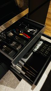 a black drawer with a knife and other utensils at Coriva Homes - Cogolo in Cogolo +21 photos