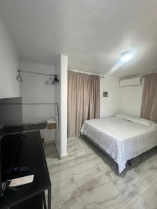 a bedroom with a bed and a table in it at Las Palomas Residences in San Juan