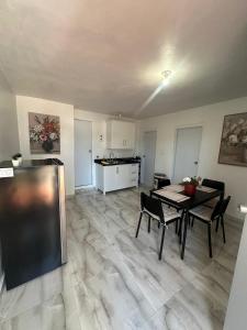 a living room with a table and chairs and a kitchen at Las Palomas Residences in San Juan