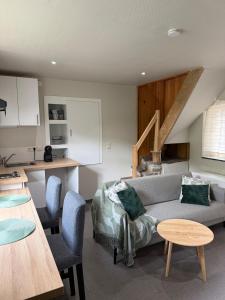 a living room with a couch and a table at Le Petit Fournil d'Aywaille in Aywaille +9 photos