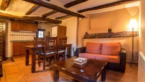 a living room with a couch and a table at Apartamentos los Aljezares in Gea de Albarracín