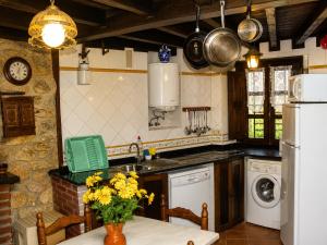a kitchen with a sink and a table with yellow flowers at La Casina de Celorio in Celorio