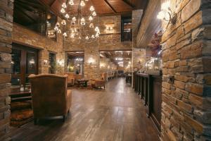 a room with a bar with chairs and a stone wall at Thermes Pozar Resort in Kato Loutraki